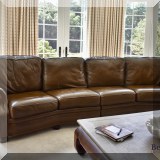 F19. Hancock & Moore curved leather sofa. 36”h x 130”w x 50”d 